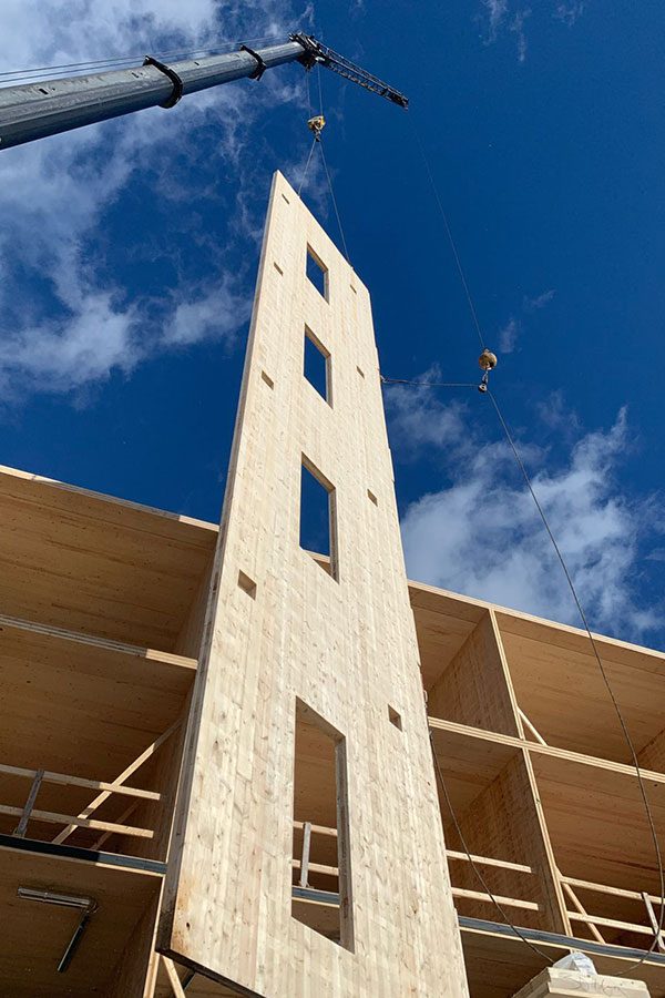 Timber stair and elevator core standing against a blue sky