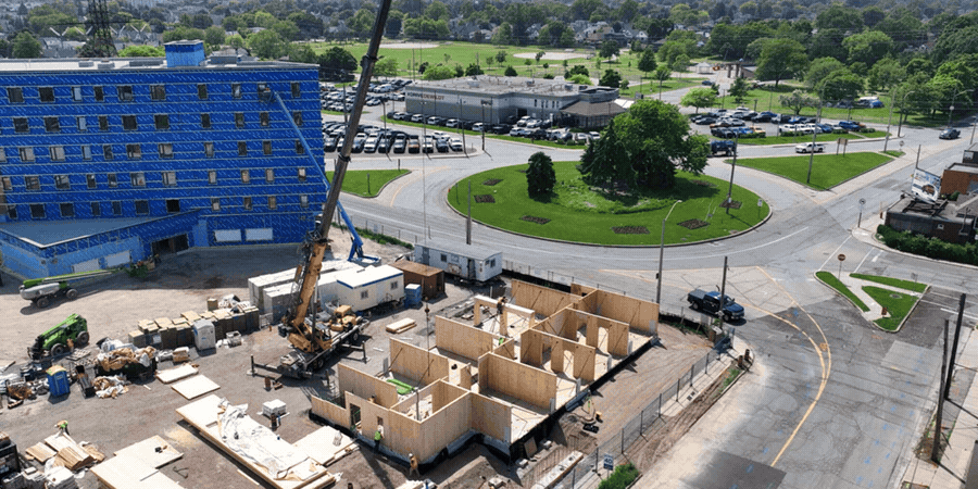 Aerial construction sequence showing 1620 Main Street East progressing from timber framing to its completed exterior