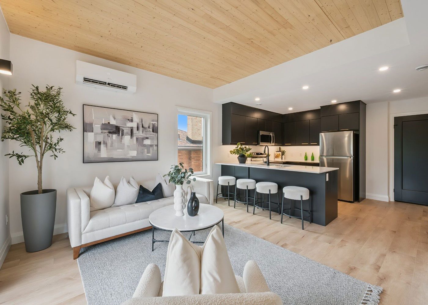 Living area with a timber-finished ceiling and open kitchen