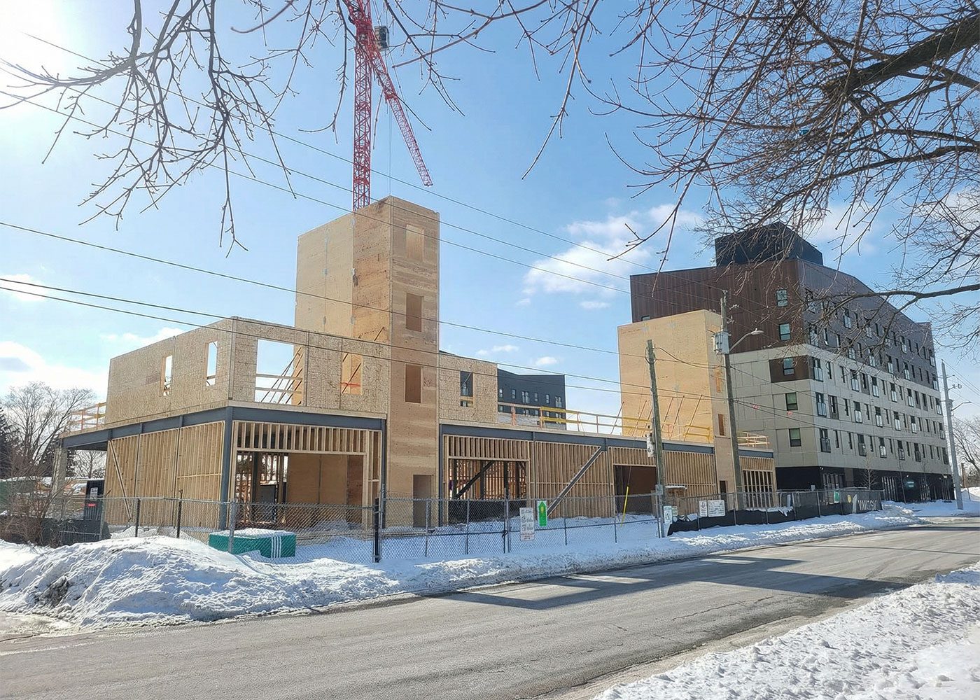 Timber core and walls rising beside the street in winter