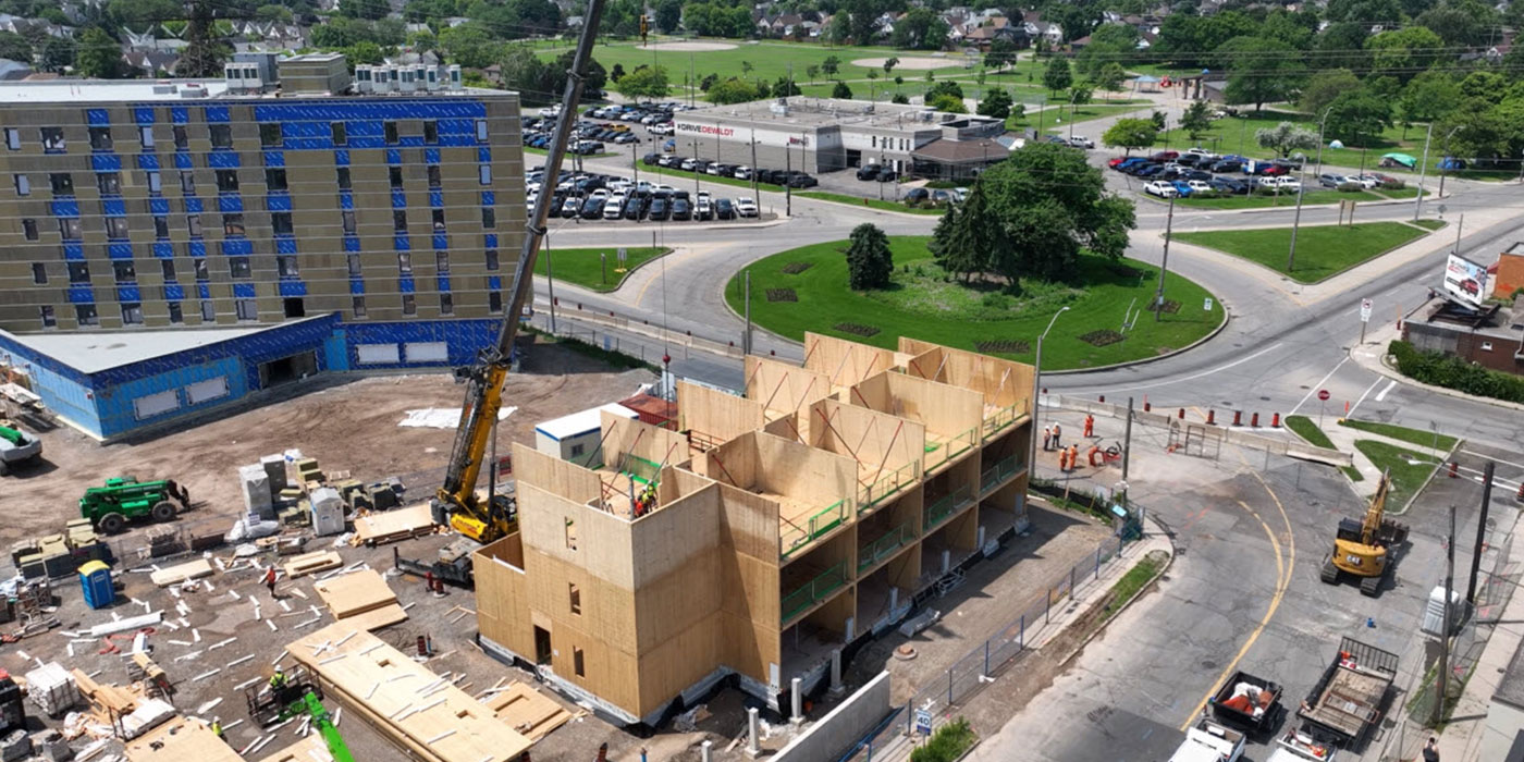Three-storey structure with mass timber panels staged on the ground